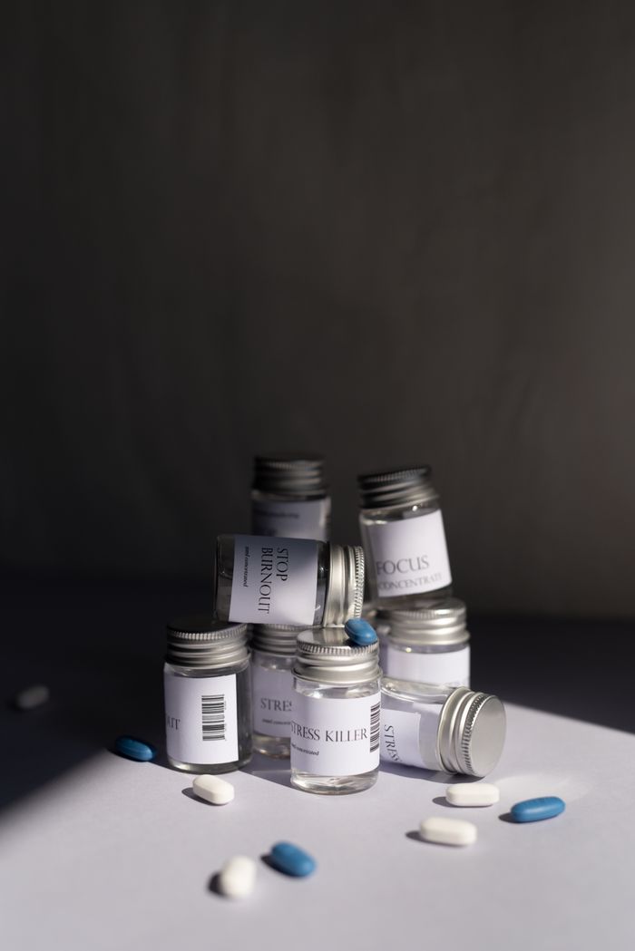 about-us-02 Various medicine bottles and pills arranged artfully on a white background.