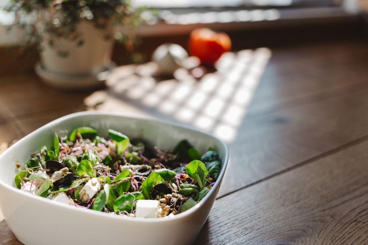 services-03 A vibrant and healthy bowl of tofu salad with fresh greens, captured in natural light on a wooden table.